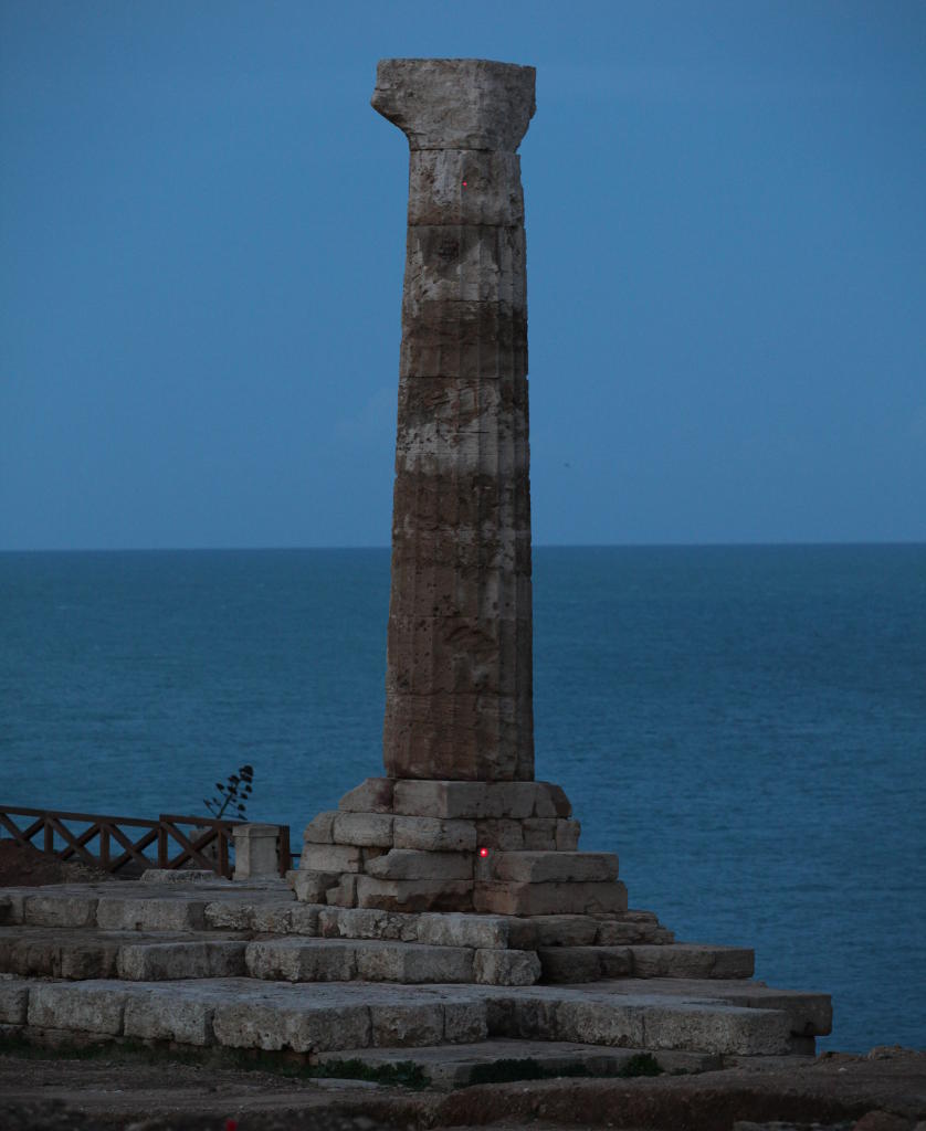 Visione notturna della colonna superstite del tempio di Hera Lacinia nell'area archeologica di Capo Colonna (KR) con in evidenza i due spot laser (macchie rosse) sul basamento e sull'ultimo rocco prima del capitello